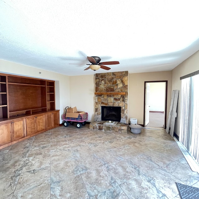 unfurnished living room with a fireplace, a textured ceiling, tile patterned floors, and ceiling fan