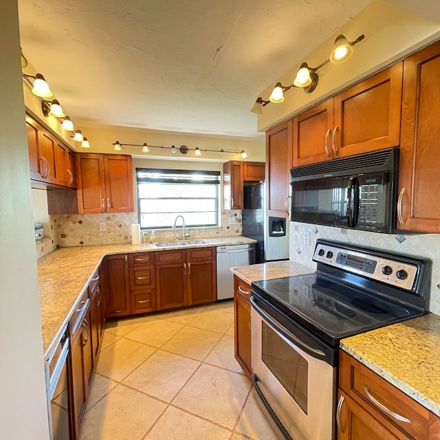 kitchen with sink, light stone countertops, appliances with stainless steel finishes, light tile patterned floors, and backsplash