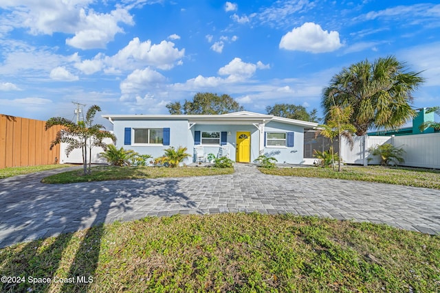 single story home featuring a garage and a front lawn