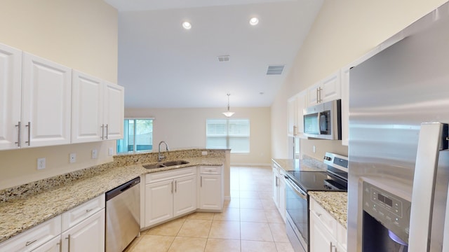 kitchen with white cabinetry, sink, hanging light fixtures, stainless steel appliances, and high vaulted ceiling