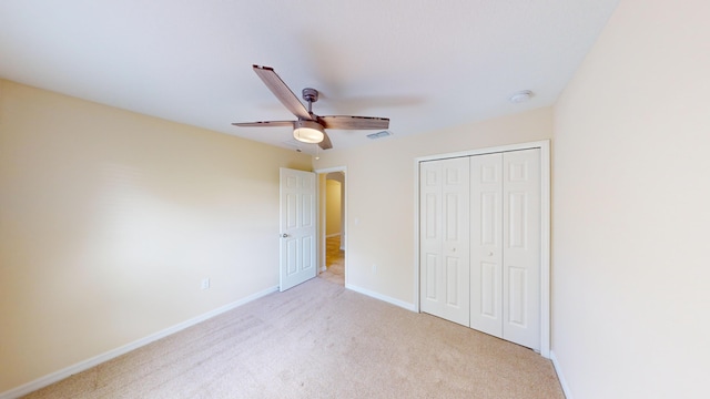 unfurnished bedroom with ceiling fan, a closet, and light colored carpet