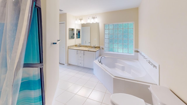 bathroom featuring tile patterned flooring, a relaxing tiled tub, toilet, and vanity