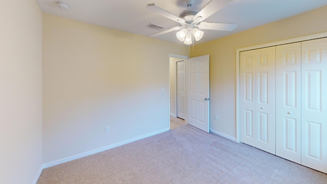 unfurnished bedroom featuring ceiling fan, light carpet, and a closet