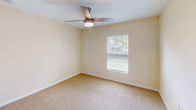 carpeted spare room with ceiling fan