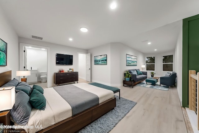 bedroom with ensuite bath and light hardwood / wood-style flooring