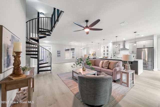 living room with ceiling fan, sink, and light hardwood / wood-style floors