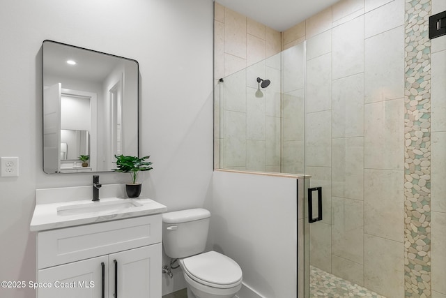 bathroom featuring walk in shower, vanity, and toilet