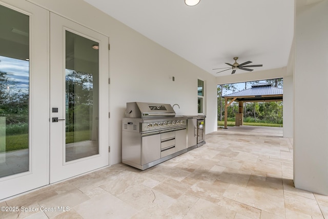 view of patio / terrace with ceiling fan, a gazebo, and exterior kitchen