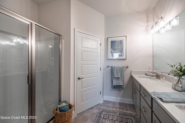 bathroom with a shower with shower door and vanity