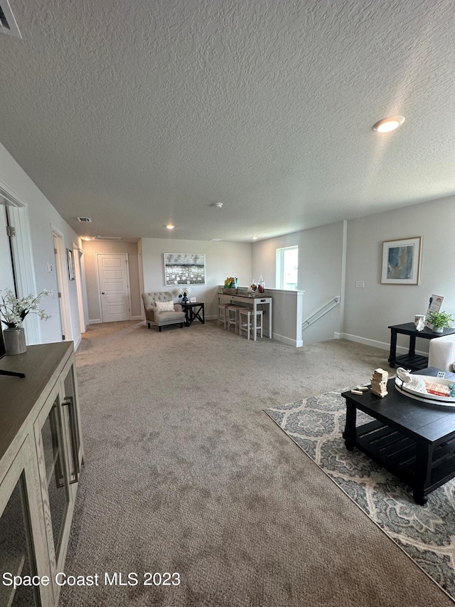 carpeted living room featuring a textured ceiling