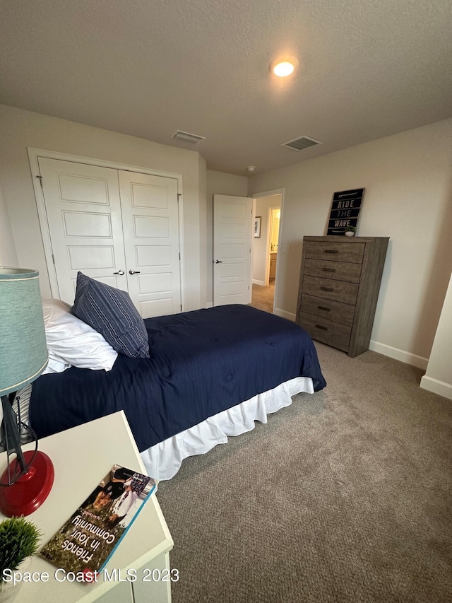 bedroom featuring a textured ceiling, a closet, and carpet