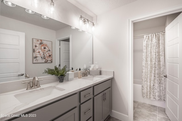 bathroom with a textured ceiling, shower / tub combo, vanity, and tile patterned flooring