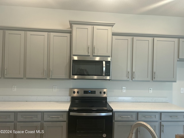 kitchen featuring black range with electric stovetop and gray cabinets