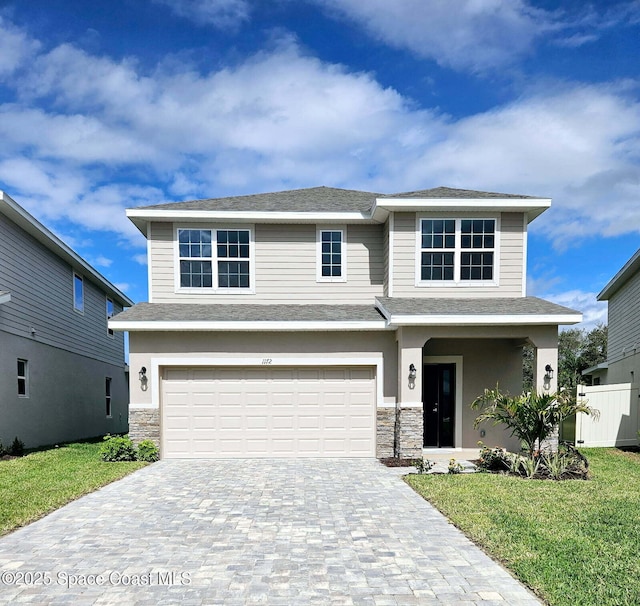 view of front of property featuring a front yard and a garage