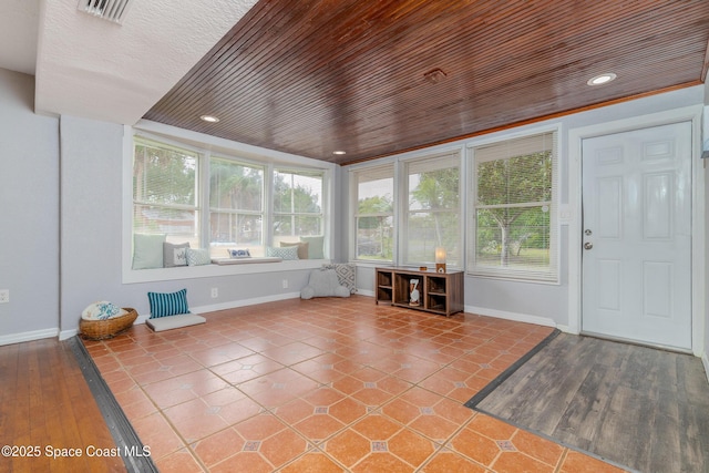 unfurnished sunroom with a healthy amount of sunlight and wooden ceiling