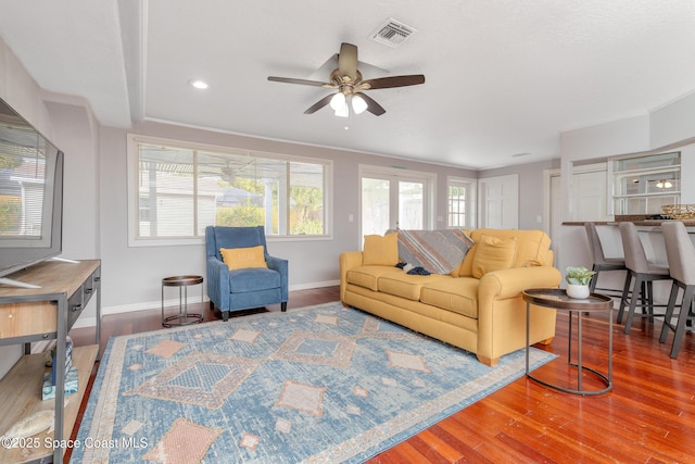 living room featuring hardwood / wood-style floors, ceiling fan, and a wealth of natural light