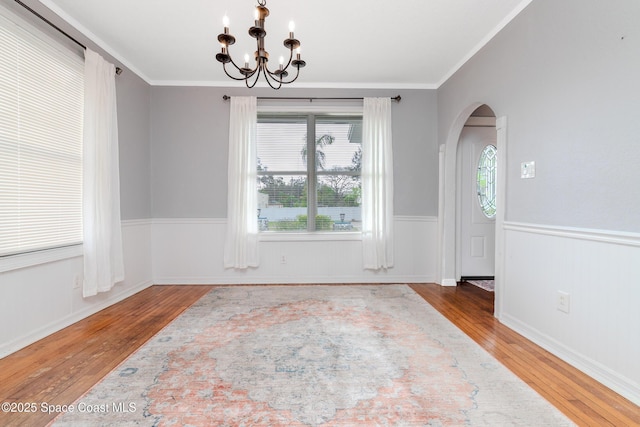 dining area with a chandelier, ornamental molding, and hardwood / wood-style flooring