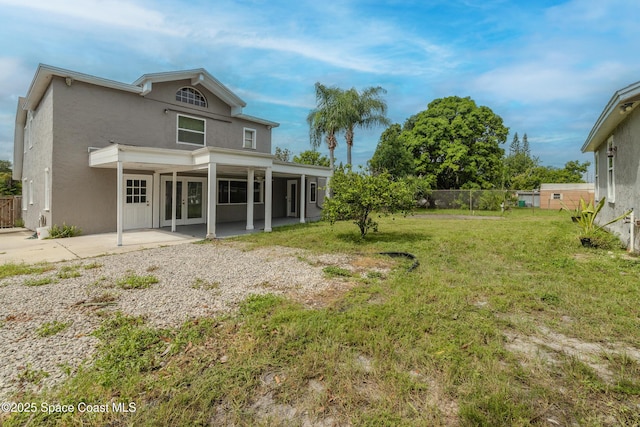 rear view of property with a yard and a patio