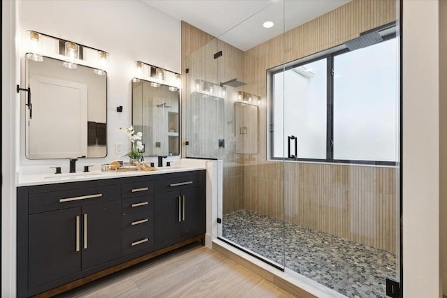 bathroom with wood-type flooring, double sink vanity, and an enclosed shower