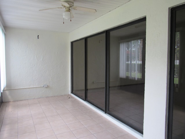 unfurnished sunroom with ceiling fan