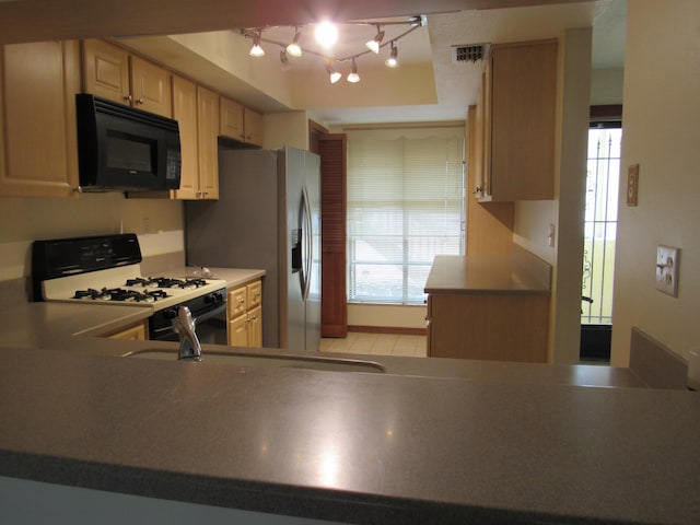 kitchen with white range with gas cooktop, plenty of natural light, and light brown cabinetry