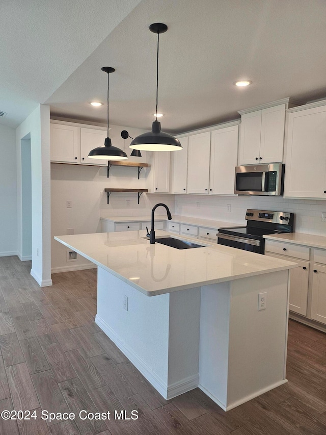 kitchen with stainless steel appliances, sink, pendant lighting, a center island with sink, and white cabinets