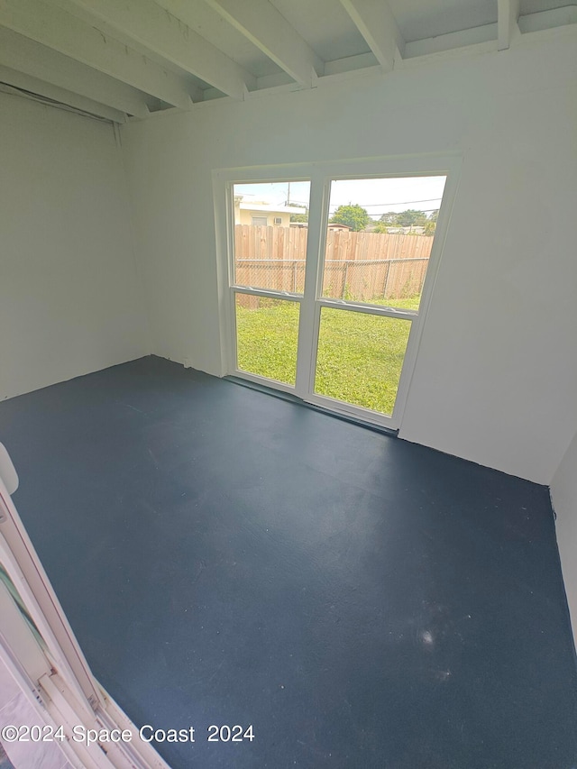 empty room featuring beamed ceiling