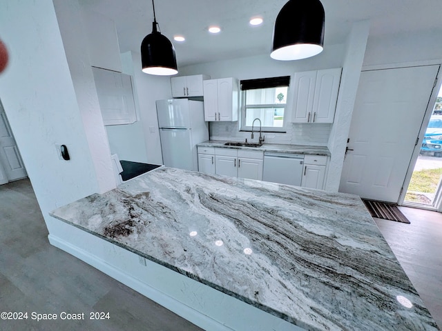 kitchen featuring sink, light stone counters, backsplash, white appliances, and white cabinets