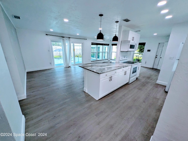 kitchen featuring light wood-type flooring, white appliances, white cabinetry, and dark stone counters