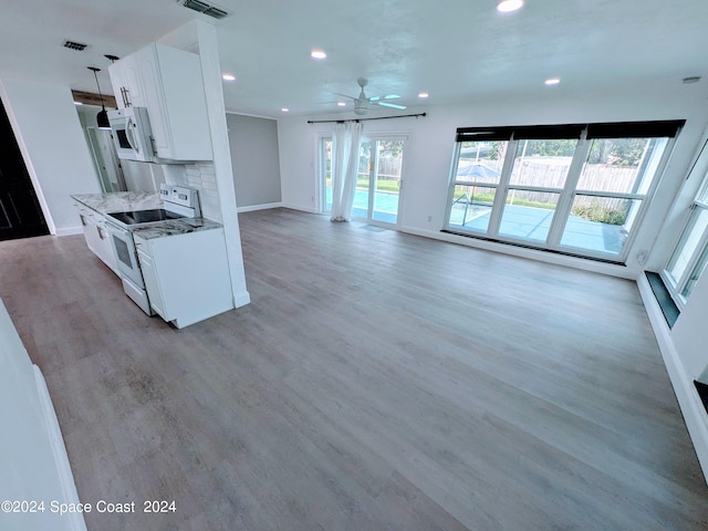 kitchen featuring white cabinets, light wood-type flooring, white appliances, and stone countertops