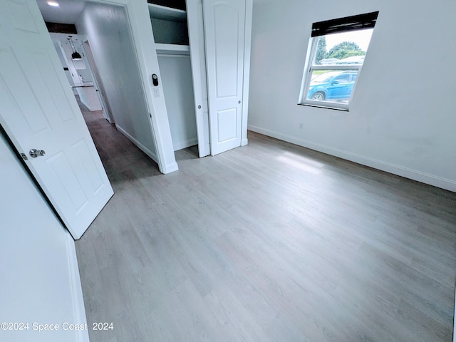 unfurnished bedroom featuring light hardwood / wood-style floors and a closet