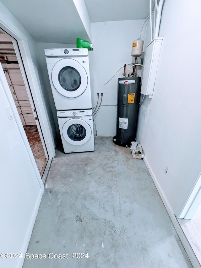 washroom featuring water heater and stacked washer and clothes dryer