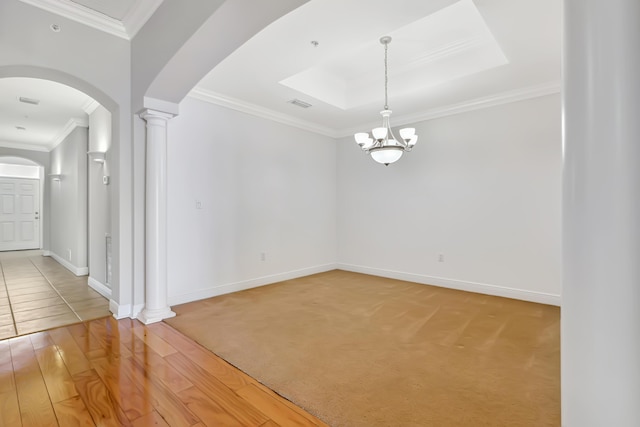 unfurnished room featuring a chandelier, ornamental molding, hardwood / wood-style flooring, and decorative columns