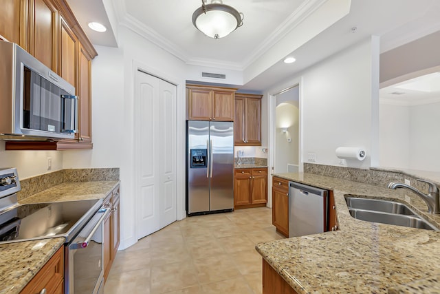 kitchen featuring light stone counters, light tile patterned floors, crown molding, appliances with stainless steel finishes, and sink