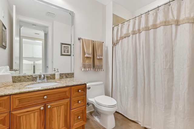 bathroom featuring toilet, tile patterned flooring, and vanity