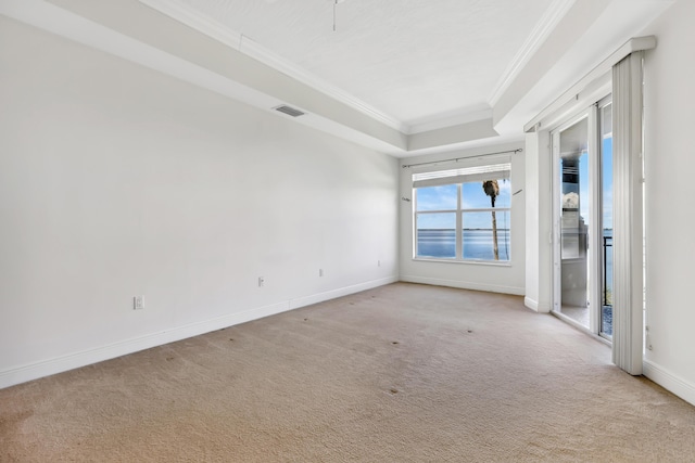 unfurnished room with light carpet, a tray ceiling, and ornamental molding