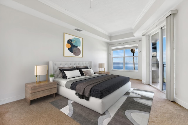 bedroom with ornamental molding, a tray ceiling, and light carpet