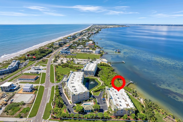 birds eye view of property featuring a beach view and a water view