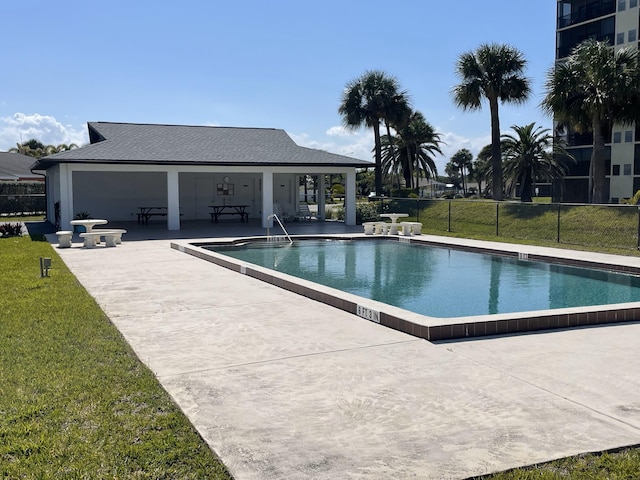 view of pool with a lawn and a patio