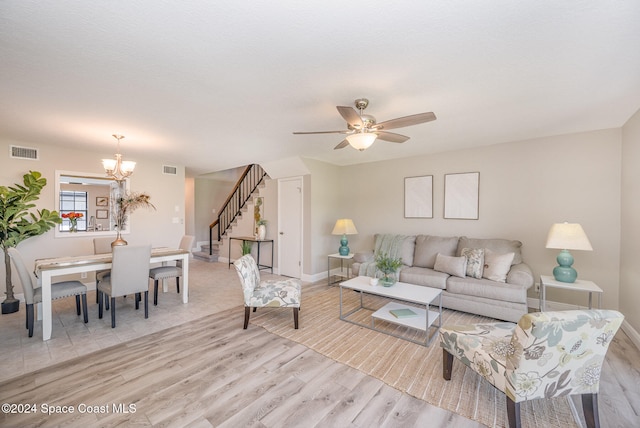 living room with ceiling fan with notable chandelier and light wood-type flooring