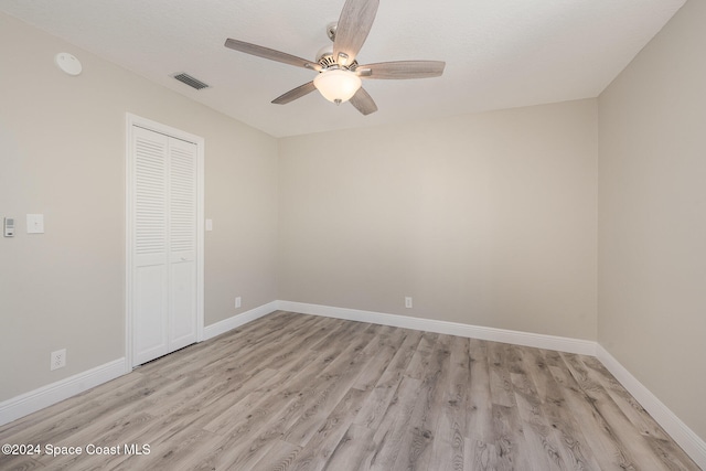 empty room with ceiling fan and light hardwood / wood-style floors