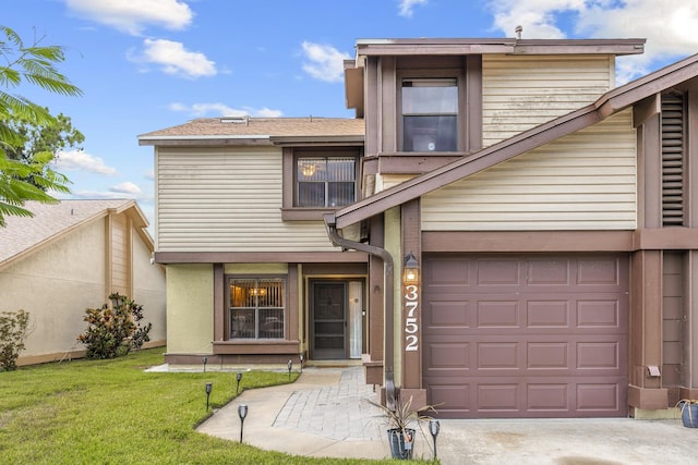 view of front facade with a front yard and concrete driveway