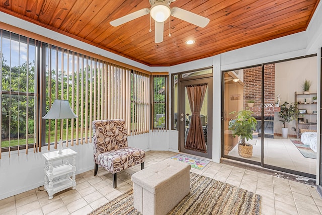 sunroom featuring wooden ceiling, ceiling fan, and a healthy amount of sunlight