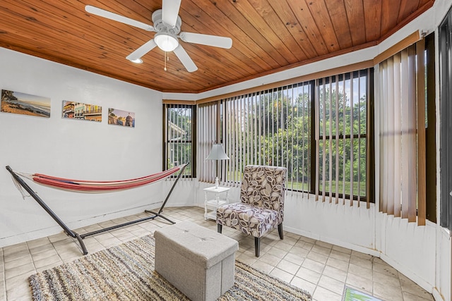 living area with a ceiling fan, light tile patterned flooring, wood ceiling, and baseboards