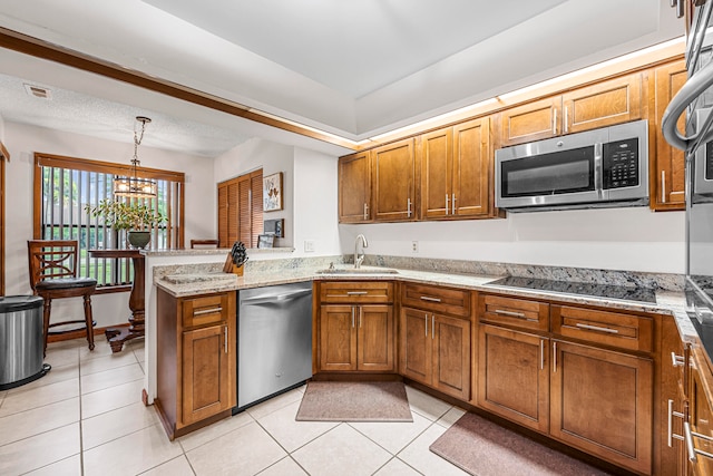 kitchen featuring stainless steel appliances, sink, kitchen peninsula, light tile patterned flooring, and a notable chandelier