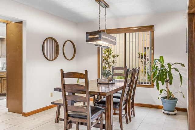 dining room featuring light tile patterned flooring, sink, and a textured ceiling