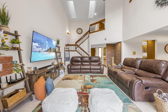 tiled living room featuring a high ceiling, brick wall, and a fireplace