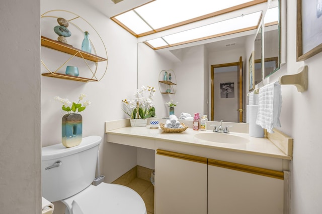 bathroom with visible vents, a skylight, vanity, and toilet