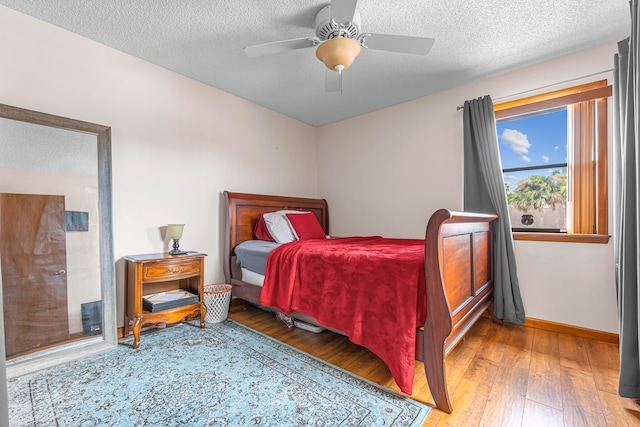 bedroom with wood-type flooring, a textured ceiling, and ceiling fan