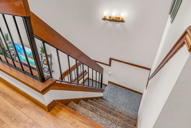 staircase featuring hardwood / wood-style flooring and a towering ceiling